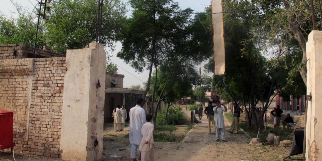 July 30, 2013: A plainclothes police officer takes a photo with his mobile phone of a damaged gate of center jail caused by Taliban militants attacked in Dera Ismail Khan, Pakistan.