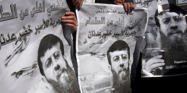 Feb. 21: Palestinians hold posters during a demonstration in solidarity with Islamic Jihad member Khader Adnan, who has been on hunger strike for two months, in the West Bank city of Nablus.