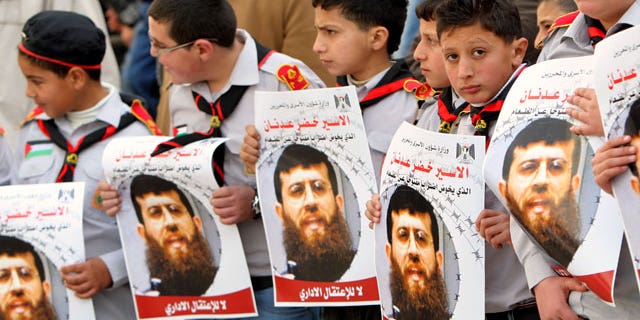 Feb. 9, 2012: Palestinian school-boys hold images of Khader Adnan, 33, a senior member of Islamic Jihad jailed in Israel who has been on hunger strike for 55 days, during a protest in solidarity with his action, and calling for the release of Palestinian prisoners jailed in Israel, in the West Bank city of Jenin.