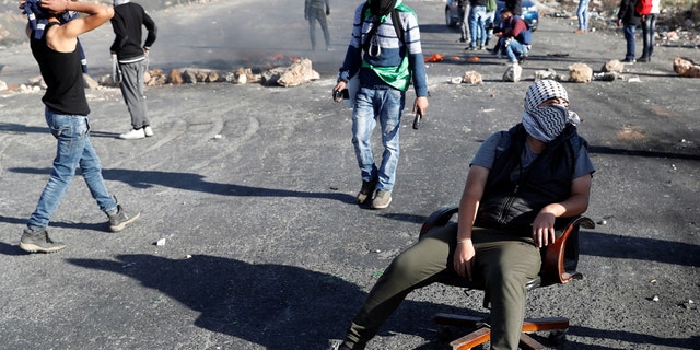 A protester sits in a chair in front of a barricade during a protest against U.S. President Donald Trump's decision to recognize Jerusalem as the capital of Israel.