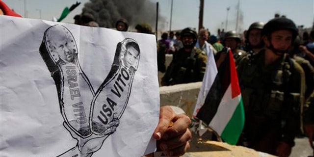 September 17: A Palestinian holds a mock poster with the image of Israeli Prime Minister Benjamin Netanyahu and U.S. President Barack Obama during a demonstration demanding the recognition of a Palestinian state, in the Qalandia checkpoint between the West Bank city of Ramallah and Jerusalem.