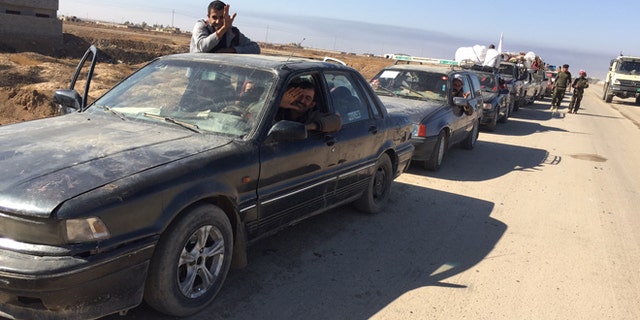 Cars line up at a checkpoint as Iraqis flee Mosul.