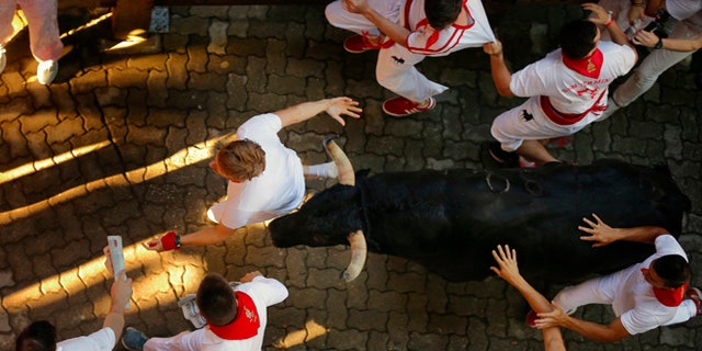 Revelers are chased by Fuente Ymbro's ranch fighting bulls in the 2016 San Fermin fiestas in Pamplona, Spain, Thursday, July 7, 2016. Revelers from around the world turned out here to kick off the festival with a messy party in the Pamplona town square, one day before the first of eight days of the running of the bulls. (AP Photo/Daniel Ochoa de Olza)