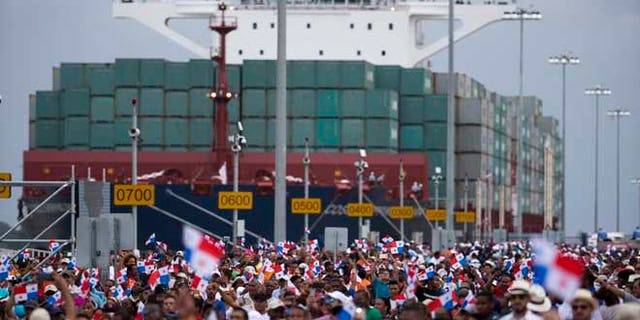 Thousands of spectators watch as the Neopanamax cargo ship, Cosco Shipping Panama, makes its way through the new Agua Clara locks, part of the Panama Canal expansion project, near the port city of Colon, Panama, Sunday June 26, 2016. The ship carrying more than 9,000 containers entered the newly expanded locks that will double the Panama Canal's capacity in a multibillion-dollar bet on a bright economic future despite tough times for international shipping. (AP Photo/Moises Castillo)