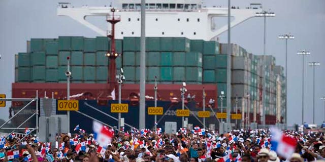 Thousands of spectators watch as the Neopanamax cargo ship, Cosco Shipping Panama, makes its way through the new Agua Clara locks, part of the Panama Canal expansion project, near the port city of Colon, Panama, Sunday June 26, 2016. The ship carrying more than 9,000 containers entered the newly expanded locks that will double the Panama Canal's capacity in a multibillion-dollar bet on a bright economic future despite tough times for international shipping. (AP Photo/Moises Castillo)
