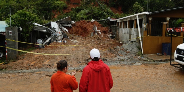 Civil Defense workers look the area where a couple was killed after their home was destroyed by a mudslide in Arraijan on the outskirts of Panama City, Tuesday, Nov. 22, 2016.
