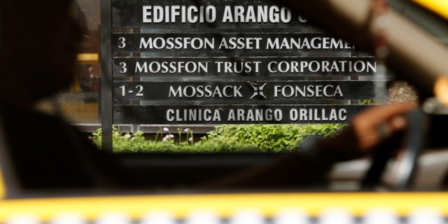 A taxi passes a company list showing the Mossack Fonseca law firm at the Arango Orillac Building in Panama City May 9, 2016. (REUTERS/Carlos Jasso)