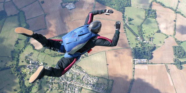 Skydiver in freefall high up in the air on a sunny day