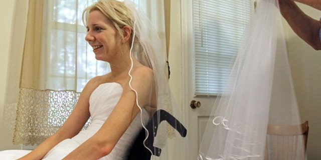 In this June 30, 2011 photo, Rachelle Friedman tries on a veil during the fitting for her wedding dress in Raleigh, N.C. Friedman was left paralyzed after a swimming pool accident that postponed her wedding plans. Now, she is all set to commence with those plans.