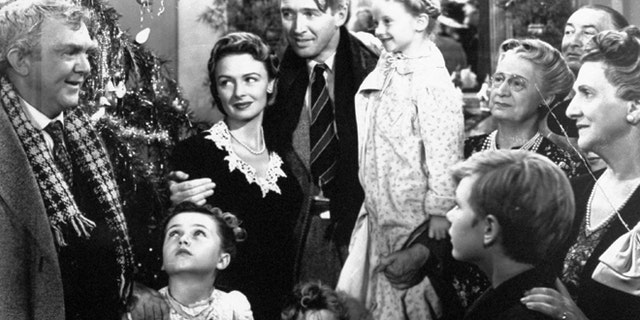 In this 1946 file photo originally provided by RKO Pictures Inc., legendary actor James Stewart as George Bailey, center, is reunited with his wife played by actress Donna Reed, third from left, and family during the last scene of Frank Capra's "It's A Wonderful Life."