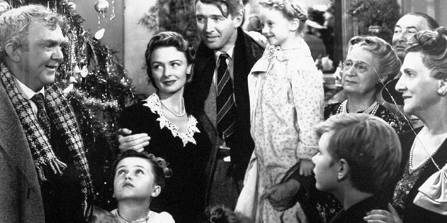 In this 1946 file photo originally provided by RKO Pictures Inc., legendary actor James Stewart as George Bailey, center, is reunited with his wife played by actress Donna Reed, third from left, and family during the last scene of Frank Capra's "It's A Wonderful Life."