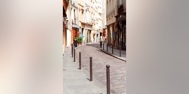 Small street with cobblestone pavement in historic center of Paris, France