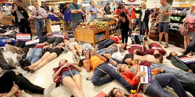 Demonstrators lie on the floor at a Publix Supermarket in Coral Springs, Fla., Friday, May 25, 2018.