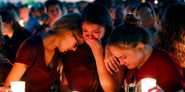 Estudiantes se consuelan entre el llanto durante una vigila por las vÃctimas del tiroteo del miércoles en la Escuela Secundaria Marjory Stoneman Douglas de Parkland, Florida, el jueves 15 de febrero de 2018. (AP Foto/Gerald Herbert)