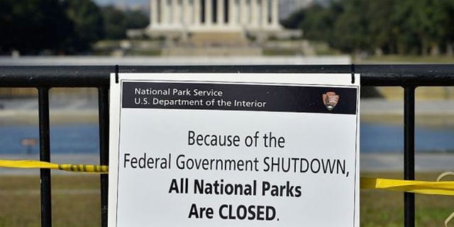 A National Park Service employee posted a sign on a barricade to close the Lincoln Memorial.