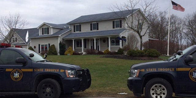 New York State Police vehicles parked outside the murder scene.