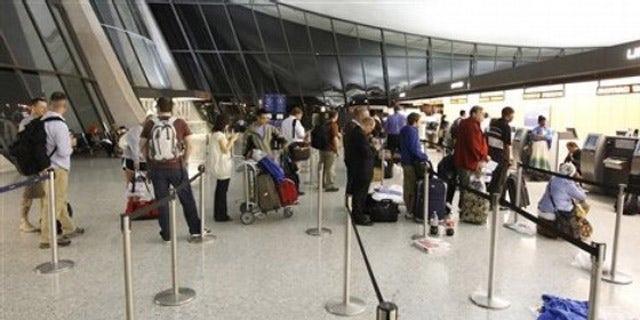 Airline passengers wait at the ticket counter of Washington Dulles International Airport in Chantilly, Va., June 18.