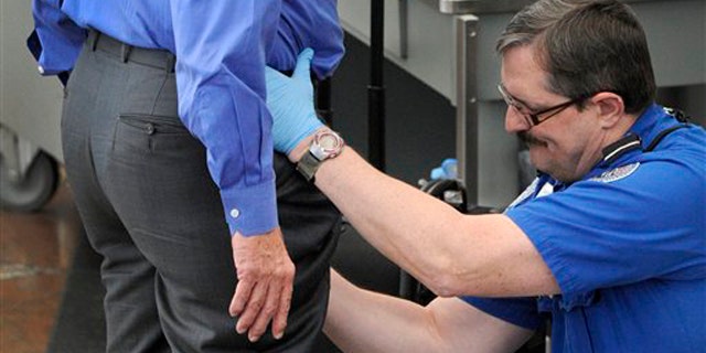 In this Nov. 17 photo, a Transportation Security Administration agent performs an enhanced pat-down on a traveler at Denver International Airport. (AP Photo)