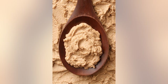 Top view of wooden spoon full of foie gras spread