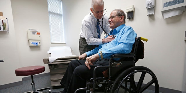 FILE: A doctor treats a patient at his office in Peoria, Illinois.