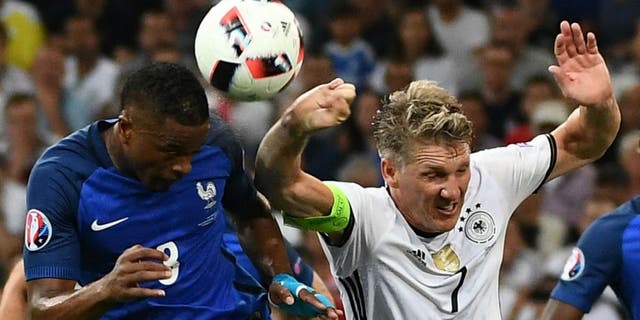 Germany's midfielder Bastian Schweinsteiger (R) touches the ball with his hand as he jumps with France's defender Patrice Evra (L), leading to a penalty for France, during the Euro 2016 semi-final football match between Germany and France at the Stade Velodrome in Marseille on July 7, 2016. / AFP / ANNE-CHRISTINE POUJOULAT (Photo credit should read ANNE-CHRISTINE POUJOULAT/AFP/Getty Images)