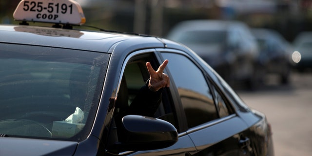 File photo - A taxi driver flashes a peace sign as he and other taxi drivers begin their protest against Uber in Montreal, Canada Oct. 5, 2016. (REUTERS/Christinne Muschi)