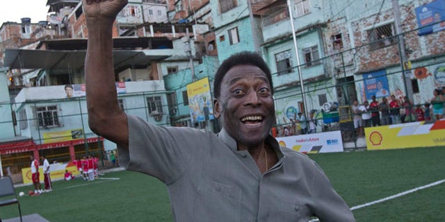 Sept. 10, 2014 Brazilian soccer great Pele pumps his fist in the air while he poses for photos during the inauguration of a soccer pitch to be powered by players' footsteps, at the Morro da Mineira favela, in Rio de Janeiro, Brazil.(AP)