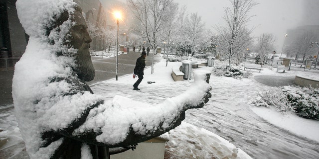 A snow-covered statue of Coca-Cola founder John Pemberton holding a glass of Coke is seen in Atlanta's Pemberton Plaza.