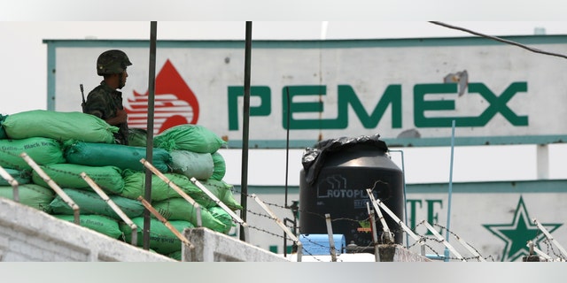 ARCHIVO - En esta foto de archivo del 11 de julio de 2007, un soldado del ejército mexicano monta guardia en una planta de la petrolera Pemex en la capital mexicana. El número de tomas ilegales en ductos de Petróleos Mexicanos se ha duplicado en lo que va de 2013, una de las pocas estadÃsticas relacionadas con delitos que, según el gobierno del presidente Enrique Peña Nieto, ha aumentado desde que asumió el cargo en diciembre pasado, dijo el gobierno el martes 23 de julio de 2013. (AP Foto/Eduardo Verdugo)