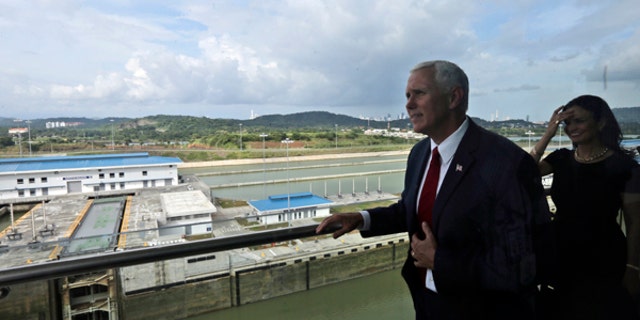 U.S. Vice President Mike Pence, photographed through a window, looks out over the Cocoli Locks during his visit to the Panama Canal in Panama City, Thursday, Aug. 17, 2017. Panama is Pence's last stop during his week-long tour of Latin America. (AP Photo/Arnulfo Franco)