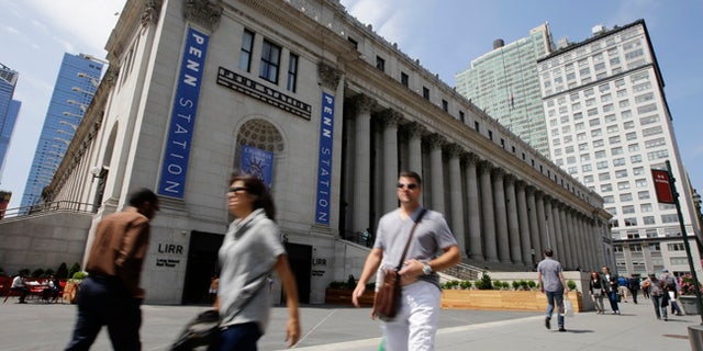 Pedestrians pass a new entrance to the West End Concourse at the Farley Post Office building Thursday, June 15, 2017, in New York. The entrance is part of the first phase of the redevelopment of the historic post office, and initially was scheduled to be opened last year. (AP Photo/Frank Franklin II)