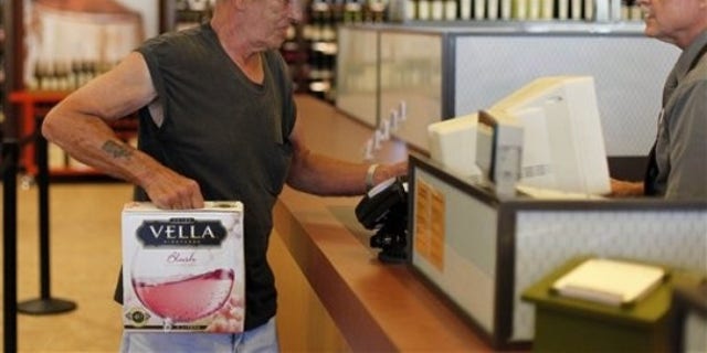 In this Thursday, July 22, 2010 photo, George Slack, left, of Lambertville N.J. makes the first purchase at a newly opened state wine and liquor store in New Hope Pa.