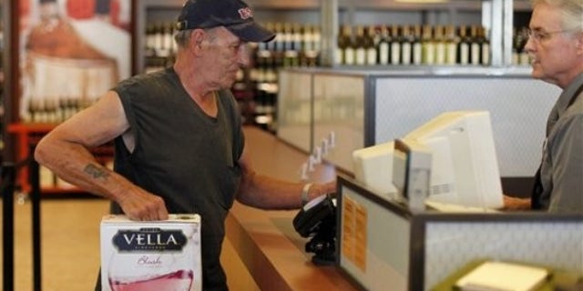 In this Thursday, July 22, 2010 photo, George Slack, left, of Lambertville N.J. makes the first purchase at a newly opened state wine and liquor store in New Hope Pa.