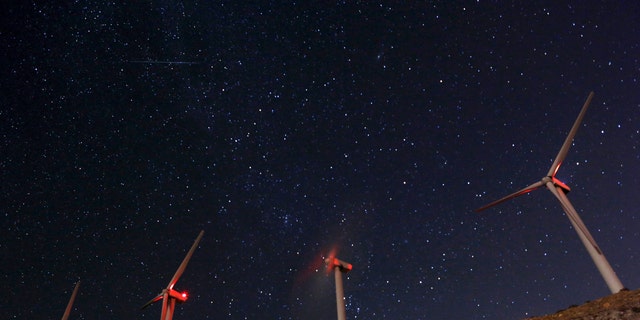 A meteor (top L) speeds past windmills at the San Gregornio Pass Wind Farm near Whitewater, Calif., Aug. 13, 2015 during the annual Perseid meteor shower. (REUTERS/Sam Mircovich)