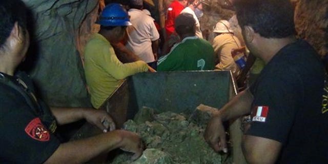 April 7, 2012: People work in a collapsed mine to rescue trapped miners in Ica, Peru. According to Peruvians authorities, nine miners trapped since Thursday in a collapsed mine are being supplied with sports drinks, soup and food while police, firefighters and other workers work to free them.