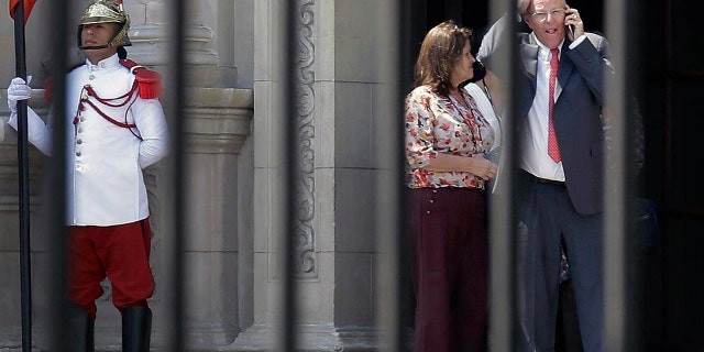 Peru's President Pedro Pablo Kuczynski talks on his cellphone as he leaves the Government Palace in Lima Wednesday.