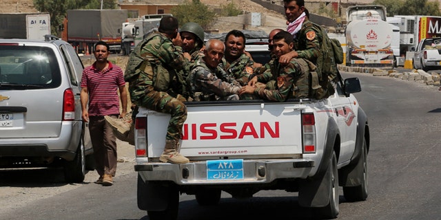 Kurdish forces, known as the Peshmerga, make their way to the front line to fight militants from the extremist Islamic State group at Mosul Dam, outside Mosul, Iraq, Monday, Aug 18, 2014.