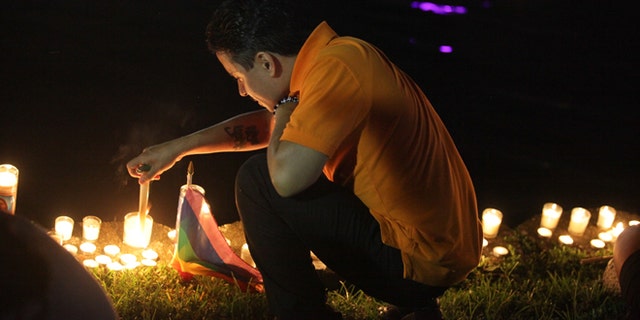 A mourner in Lake Eola Park lights a candle in memorium of the Pulse nightclub shooting victims.