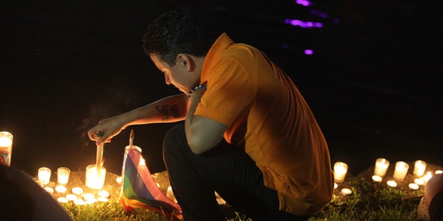 A mourner in Lake Eola Park lights a candle in memorium of the Pulse nightclub shooting victims.