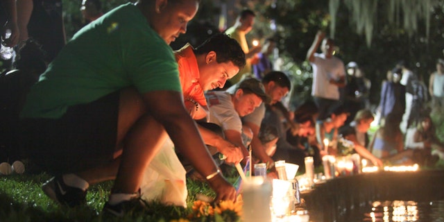 Wendy Frias, from left, and Hector Silva light candles along Lake Eola in Orlando, Sunday, June 12, 2016. The New York natives have made Orlando their home in recent years and came to the vigil for the victims of the Pulse night club tragedy.