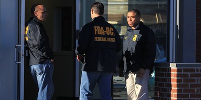 Federal agents investigate the offices of New England Compounding Center in Framingham, Mass., Tuesday, Oct. 16, 2012. The company's steroid medication has been linked to a deadly meningitis outbreak. FDA spokesman Steven Immergut says the visit is part of the investigation into the outbreak, which has killed at least 15 people and sickened more than 200 others in 15 states. (AP Photo/The Boston Globe, Barry Chin) BOSTON HERALD OUT, QUINCY OUT