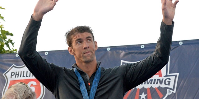 FILE 2014: Michael Phelps on the podium after getting his second place medal for the Men's 100 Meter Butterfly final at the USA Swimming Nationals at the William Woollett Jr. Aquatics Complex.