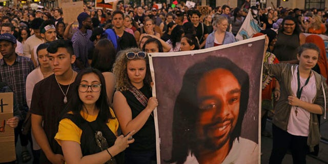 Supporters of Philando Castile hold a portrait of Castile as they march along University Avenue in St. Paul, Minn., leaving a vigil at the state Capitol on Friday, June 16, 2017. The vigil was held after St. Anthony police Officer Jeronimo Yanez was cleared of all charges in the fatal shooting last year of Castile. (Anthony Souffle/Star Tribune via AP)