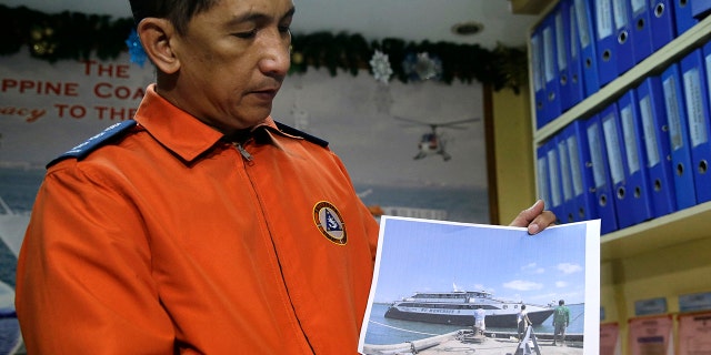 Coast guard spokesman Armand Balilo shows a file photo of the passenger vessel Mercraft 3 as he talks to reporters in Manila, Dec. 21, 2017.