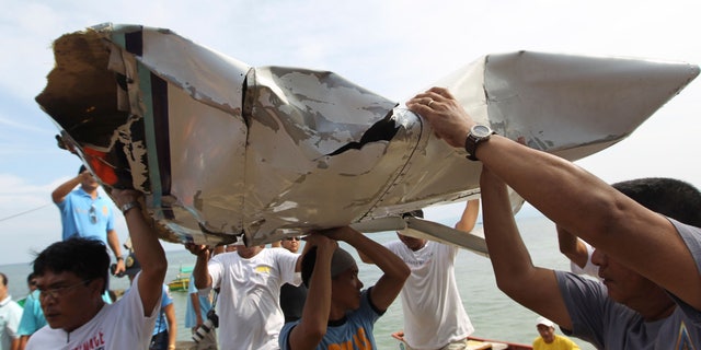 In this photo released by the Malacanang Photo Bureau, men carry parts of a crashed plane carrying Philippine Interior Secretary Jesse Robredo in Masbate city, Masbate province, central Philippines, Sunday, Aug. 19, 2012. About 300 rescuers were searching Sunday for Robredo and his two pilots after their small plane crashed into the sea while attempting an emergency landing on Saturday. (AP Photo/Malacanang Photo Bureau, Jay Morales) NO SALES