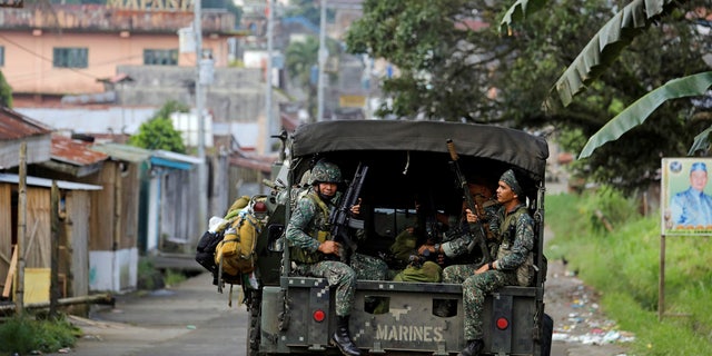 Philippine Marines ride in a military vehicle as they advance their position in Marawi City, southern Philippines May 30, 2017. REUTERS/Erik De Castro - RTX3864E