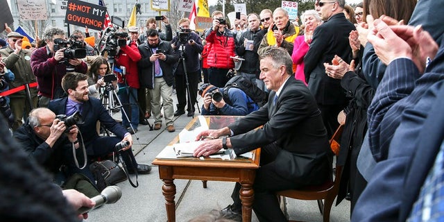 Gov. Phil Scott, in April, signing gun control legislation that drew fierce protests.