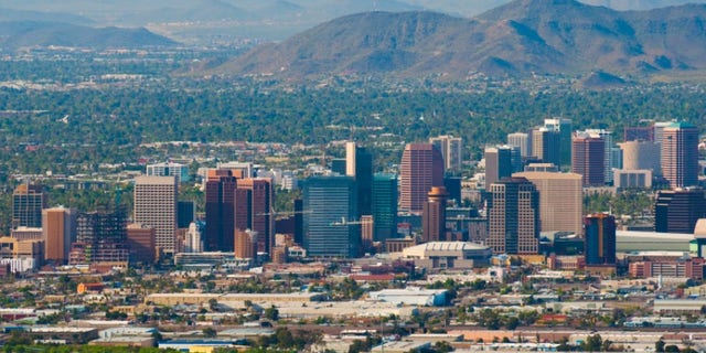 Aerial view of the Phoenix downtown skyline with the midtown skyline behind as well as North Mountain and other mountains in the background.