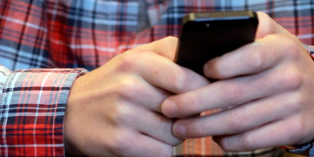 Oct. 24, 2013: This file photo shows a youth checking his smartphone in Glenview, Ill.