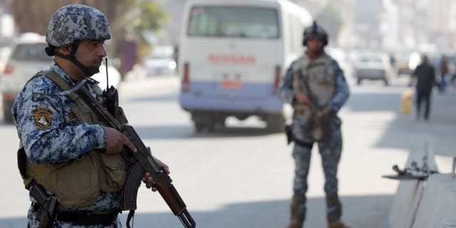 Iraqi policemen stand at a checkpoint in central Baghdad on November 29, 2012. A suicide bomber blew himself up on Tuesday at a Shiite Muslim religious hall in north Baghdad, killing at least 15 people, security officials said, the latest in a surge in nationwide violence.